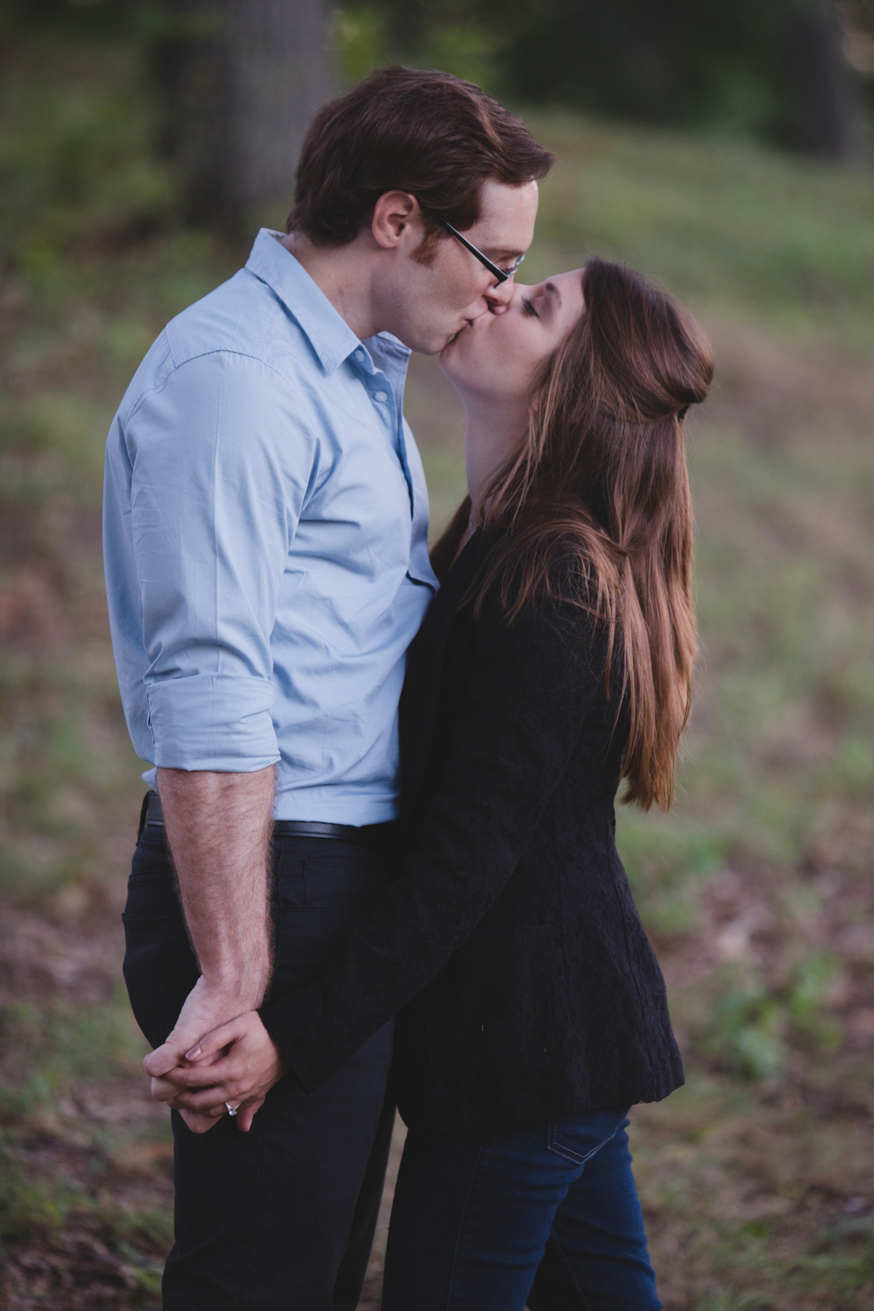 A romantic phototograph of a couple kissing at the Arnold Arboretum during their Boston engagement session