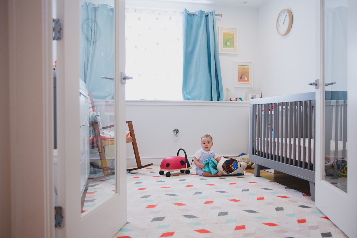 A documentary photograph of a baby boy playing in his room during a Jamaica Plain in home family photo session