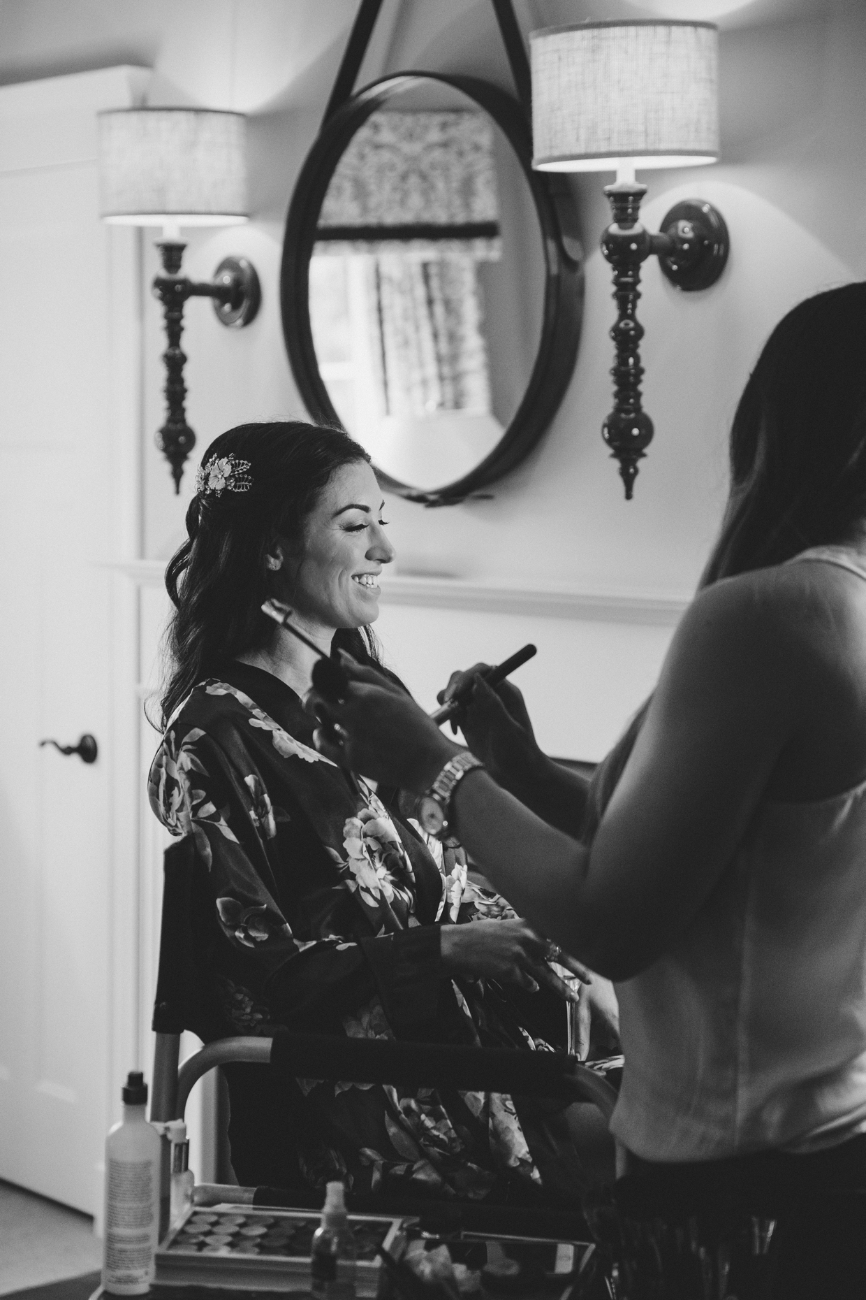 A bride gets her makeup done on the morning of her backyard wedding in Massachusetts