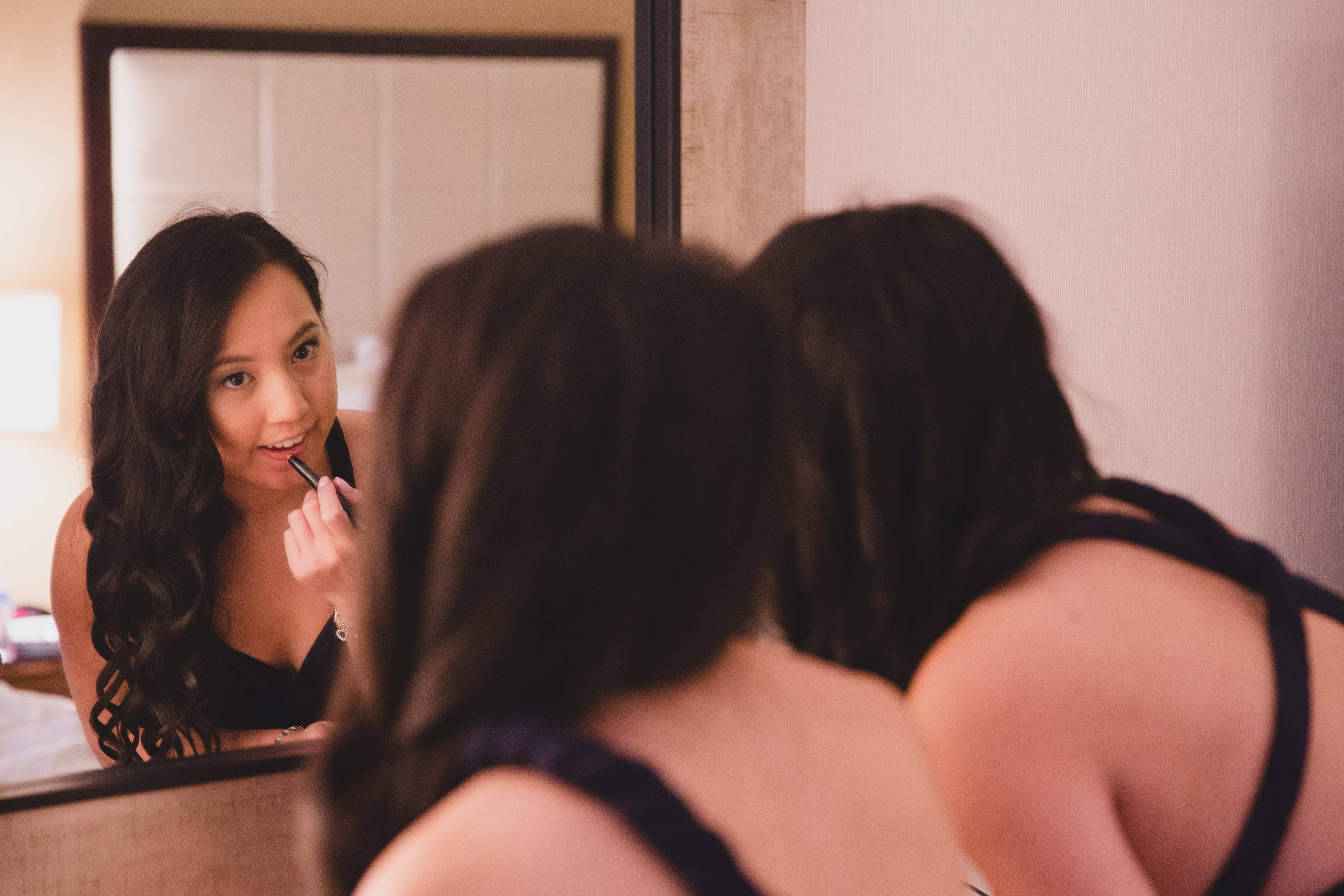 A candid photograph of bridesmaids doing their makeup before a Vietnamese Tea ceremony in Boston
