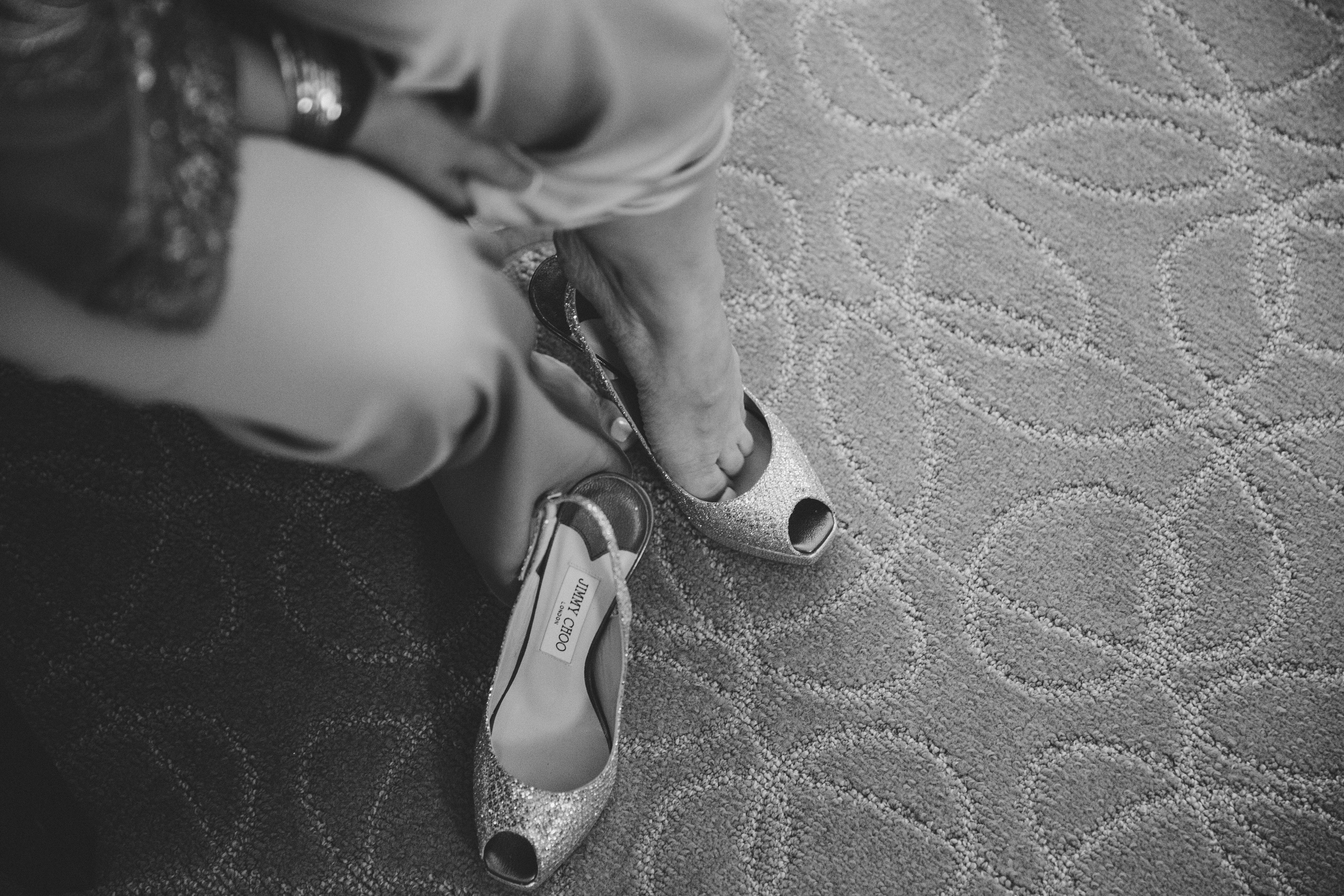 A bride puts on her Jimmy Choo shoes before her vietnamese tea ceremony in Boston