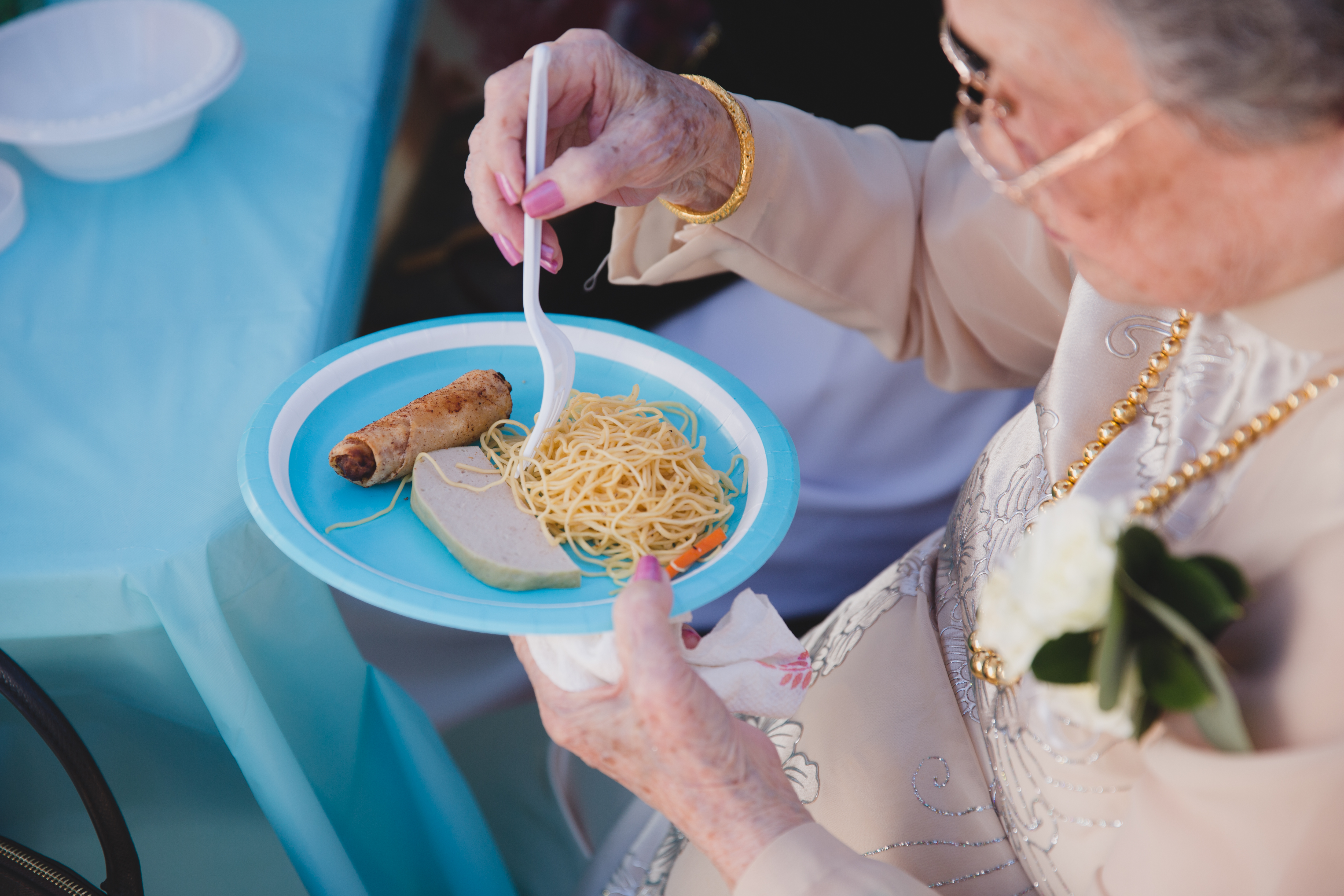 A documentary style photograph of a grandmother eating after a vietnamese tea ceremony in Boston