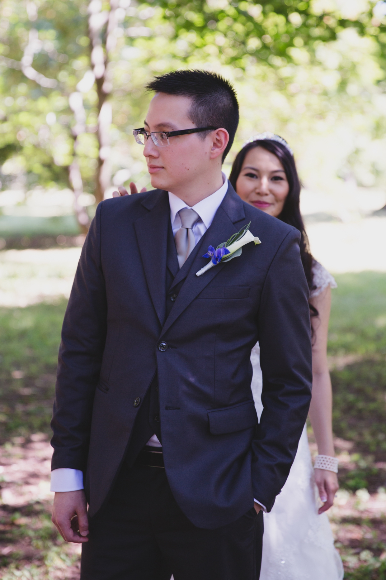 A bride taps the groom on the shoulder during their first look at the Arnold Arboretum