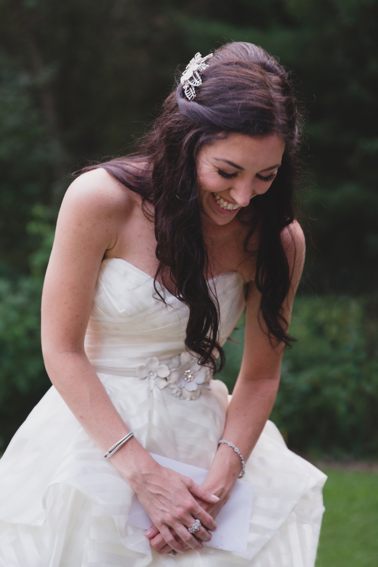 A candid photograph of a brdie laughing in her hayley paige guindon wedding dress during her backyard wedding in Massachusetts