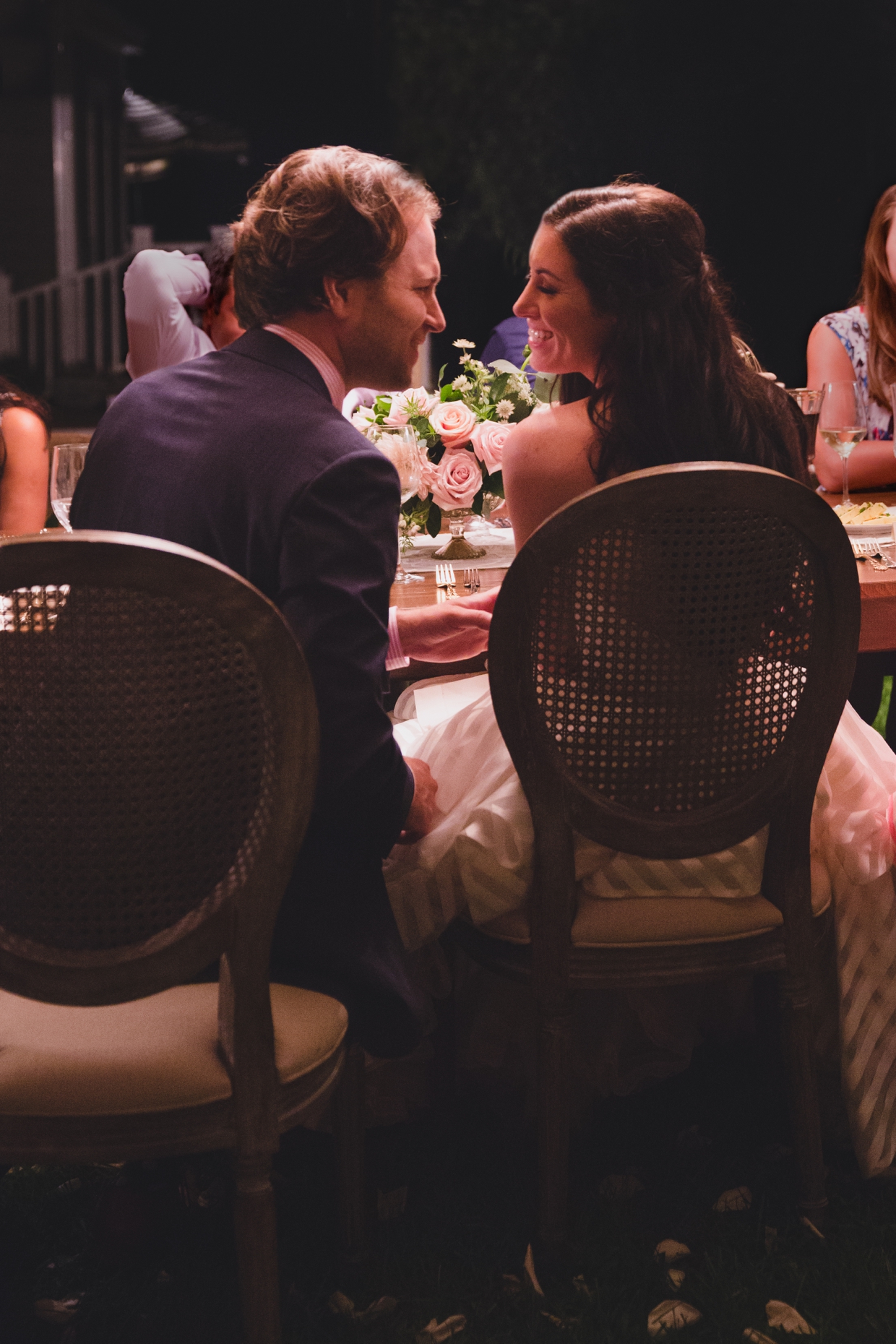 A sweet photograph of a couple during the dinner portion of their backyard wedding in Massachusetts