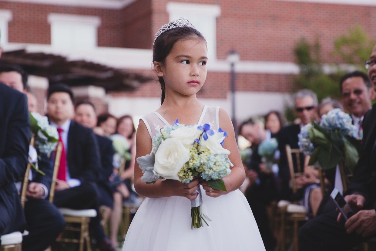 A sweet photograph of a flower girl walking up the aisle during a wedding ceremony at the Boston Marriott Hotel
