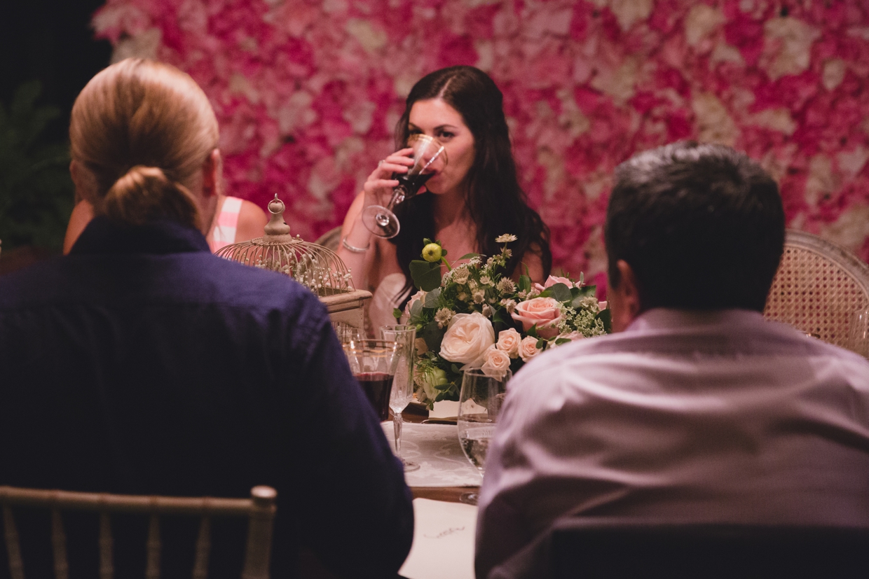 A bride takes a sip of wine during her backyard wedding in Massachusetts