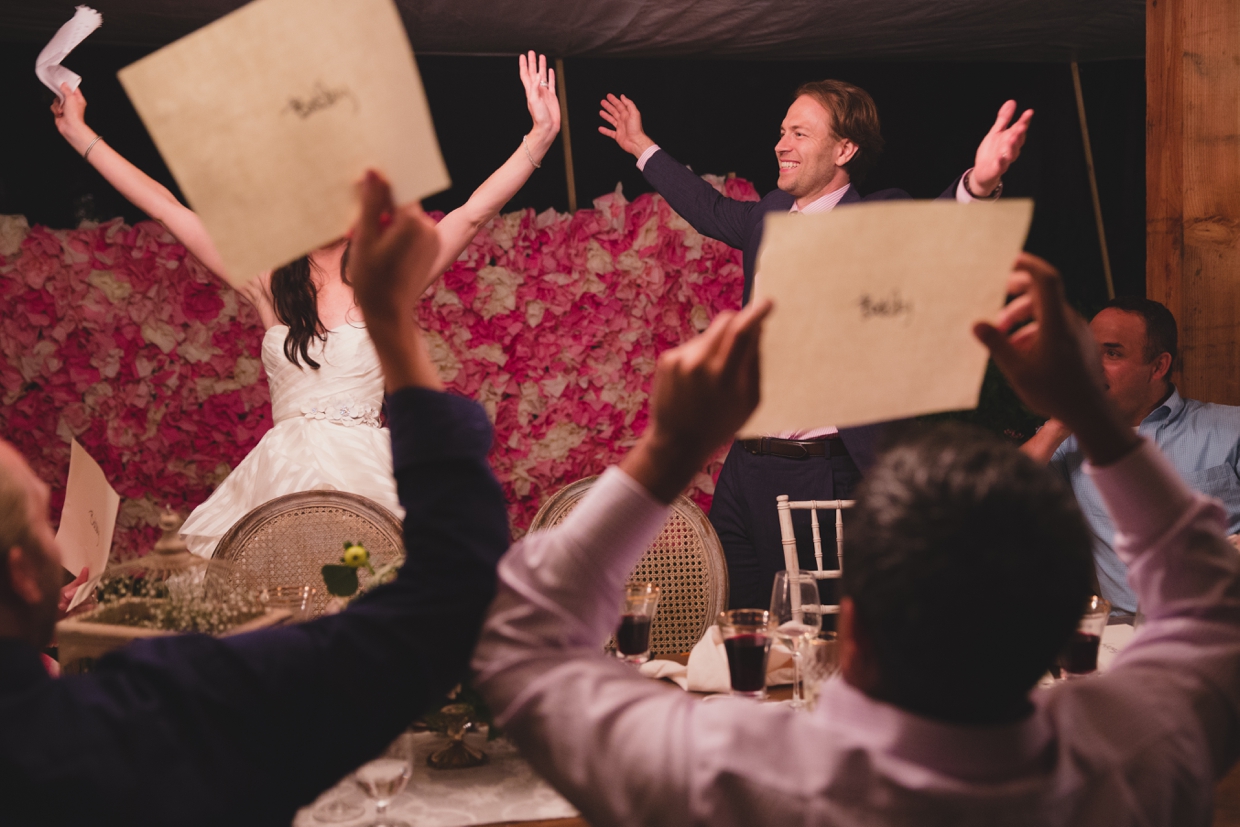 A funny and candid photograph of a bride and groom playing party games during their backyard wedding in Massachusetts