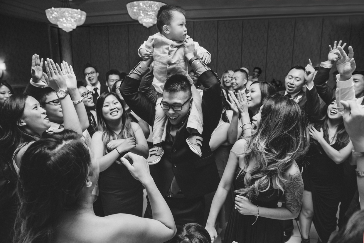 An incredible photograph of the ring bearer dancing with guests at a Boston Marriott Hotel Wedding
