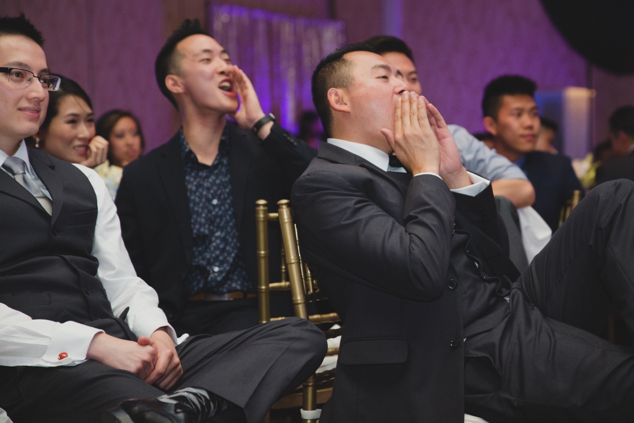 A fun photograph of the wedding party cheering during the wedding speeches at the Boston Marriott Hotel