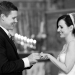 A documentary style photograph of a bride and groom exchanging wedding rings