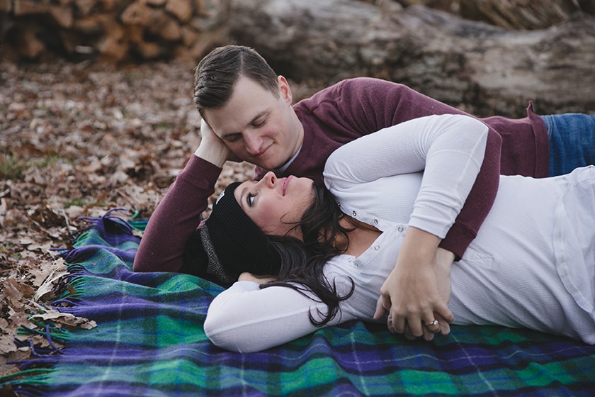 A sweet portrait of a couple laying together on a blanket during their engagement session at Borderland State Park