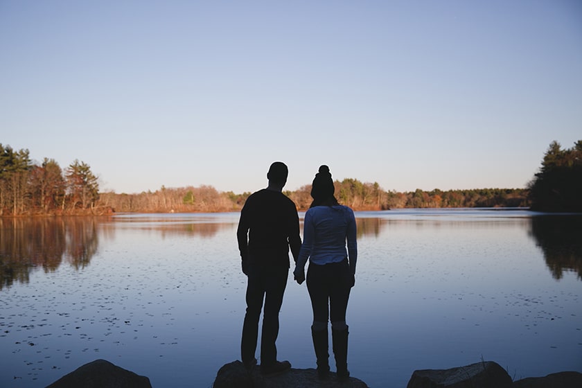 A beautiful portrait of a couple looking out on the water during their fall engagement session at Borderland State Park