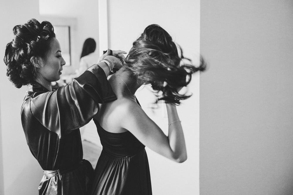 A photojournalistic photograph of a bride helping her bridesmaid get ready at the Marriott Hotel before her Boston Wedding