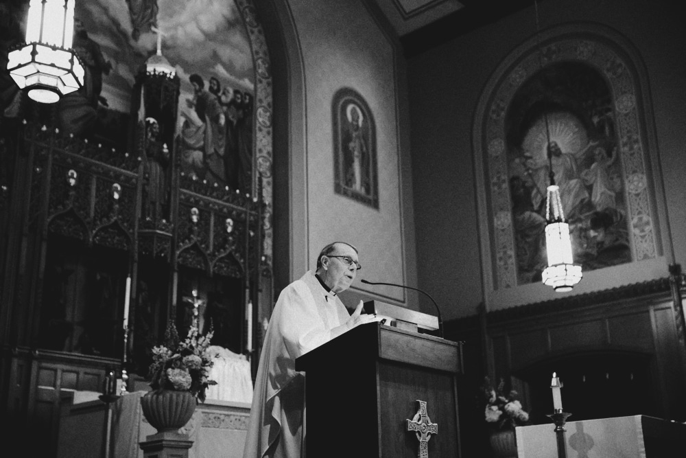 A documentary photograph of a priest during a wedding ceremony at St. Augustin's Church in Newport, Rhode Island