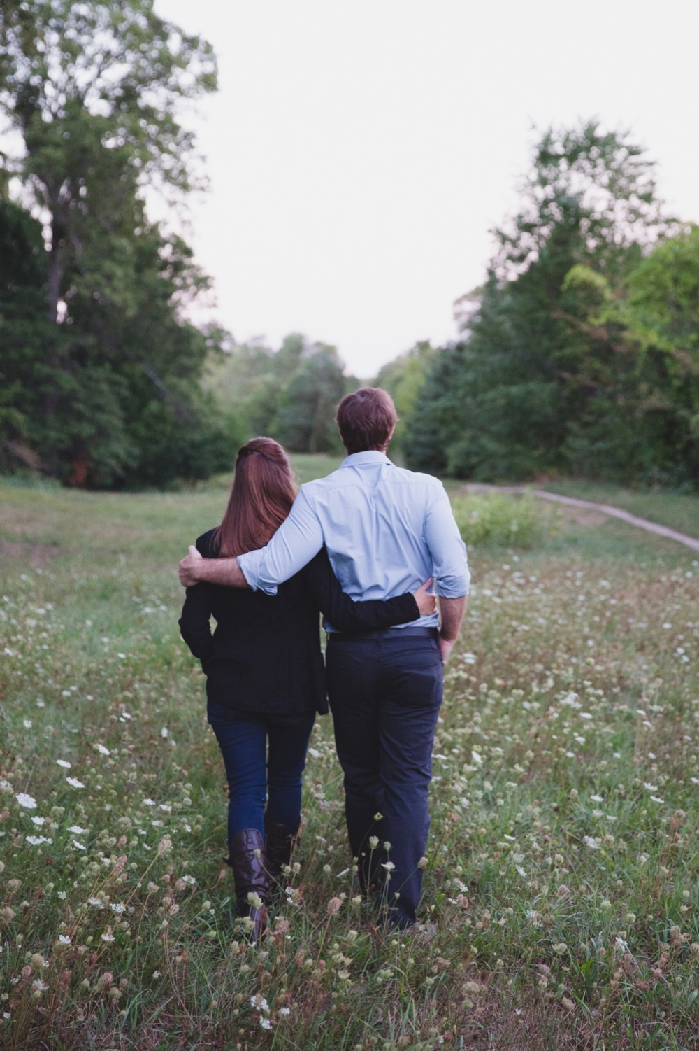 A relaxed portrait of a couple walking in the Arnold Arboretum during their Boston Engagement Session 