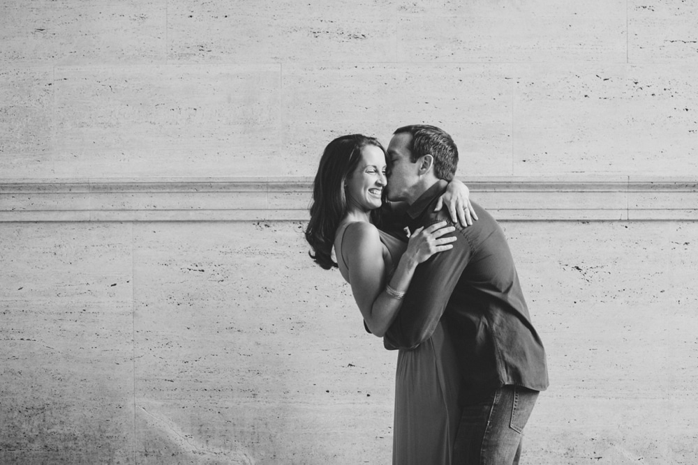 A documentary photograph of a couple hugging and laughing during their engagement session at the Massachusetts Institute of Technology