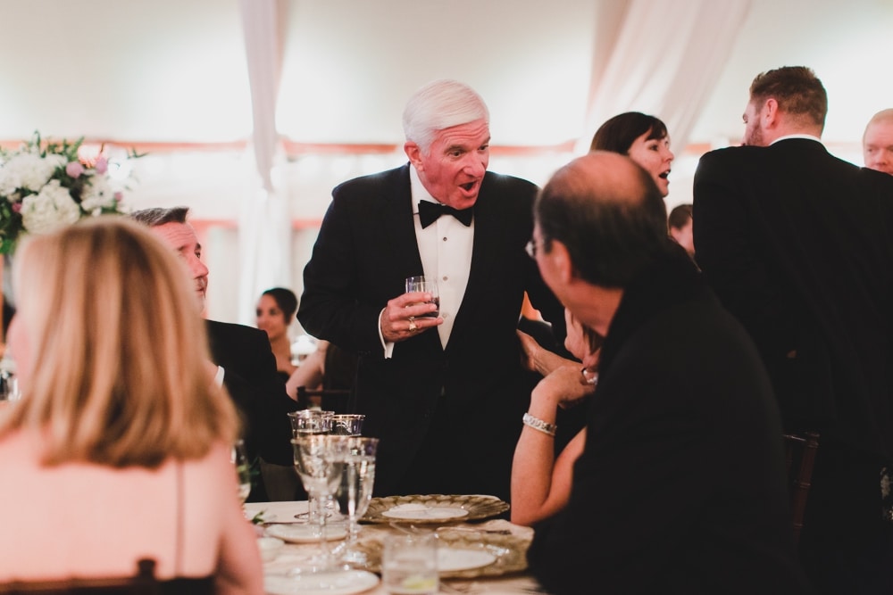 A candid photograph of a wedding guest talking during a reception at the Castle Hill Inn in Newport, Rhode Island