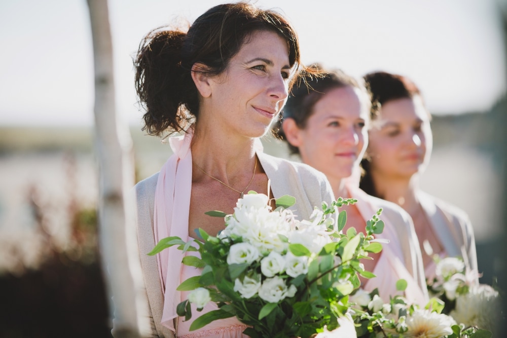 A documentary photograph of a bridesmaid watching her best friend get married at an outdoor ceremony in Cape Cod