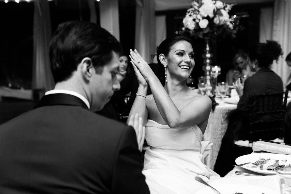 A bride claps after the wedding toast during her wedding at the Castle Hill Inn in Newport, Rhode Island