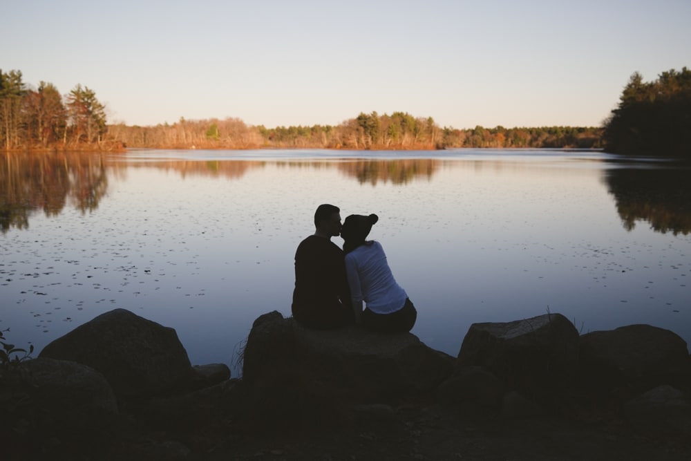 A photojournalistic engagement portrait of a couple looking out onto the water during the engagement session at Borderland State Park in Massachusetts