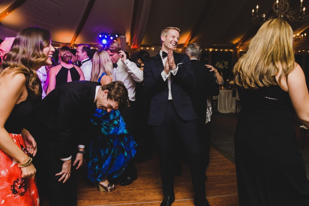 A photojournalistic photograph of guests laughing and dancing during a Castle Hill Inn Wedding in Newport, Rhode Island