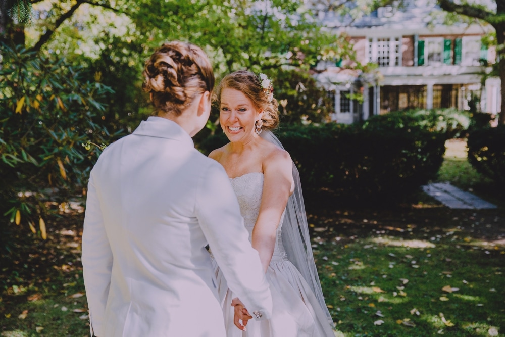 A beautiful documentary photograph of bride seeing her bride during their first look at the Governors Inn before their wedding at Kitz Farm in New Hampshire