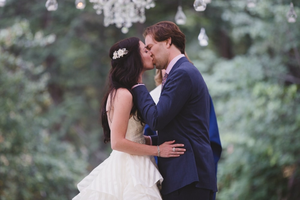 A beautiful photograph of a bride and groom kissing during their backyard wedding ceremony in Boston, Massachusetts