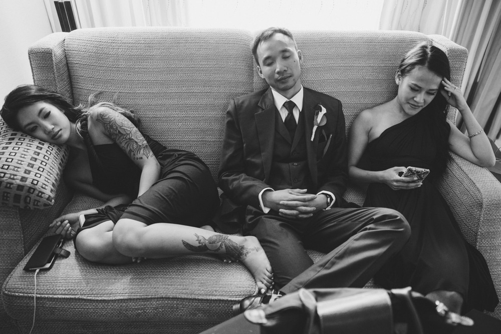 A documentary photograph of bridesmaids and a groomsman resting on the couch after a vietnamese tea ceremony in Boston, Massachusetts