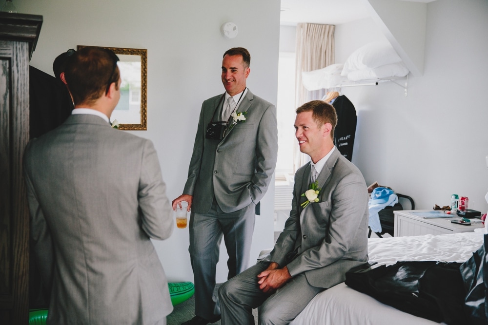 A documentary photograph of a groom getting ready with his groomsmen before a fun summer wedding at Pilgrim's Monument in Provincetown, Massachusetts