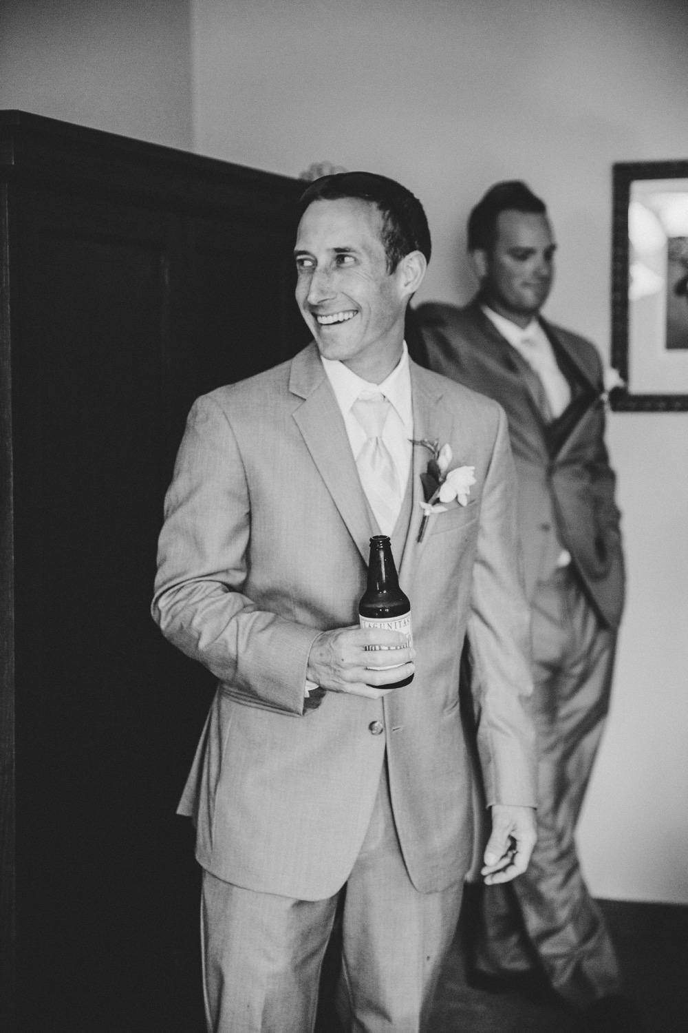 A photojournalistic photograph of a groomsmen laughing before a fun, cape cod wedding at Pilgrim's Monument in Provincetown, Massachusetts