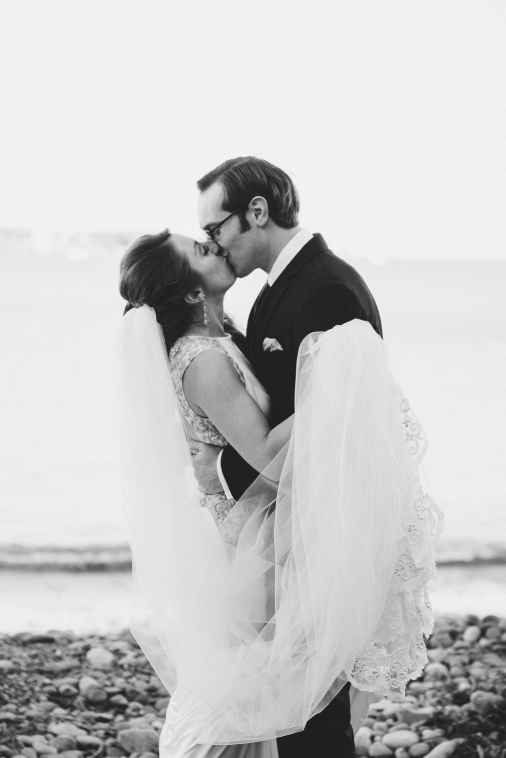 A documentary photograph of a bride and groom kissing as they see each other during the first look before their Massachusetts wedding at the Oceanview of Nahant