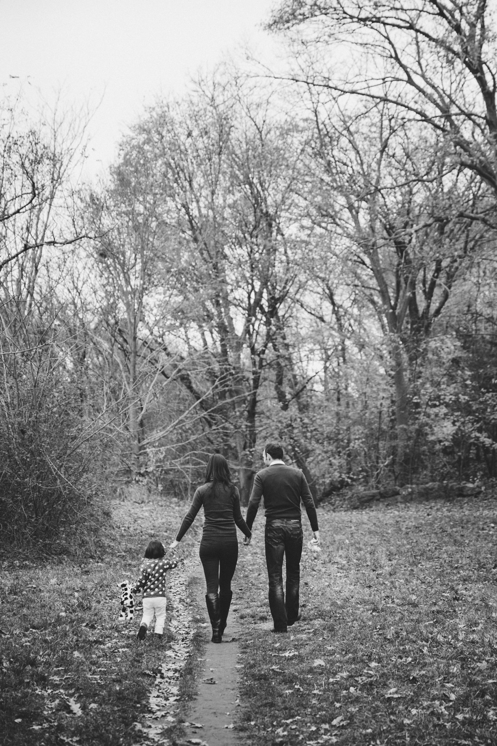 A documentary photograph of a family walking in the Arnold Arboretum during their fall mini session at the Arnold Arboretum in Boston, Massachusetts