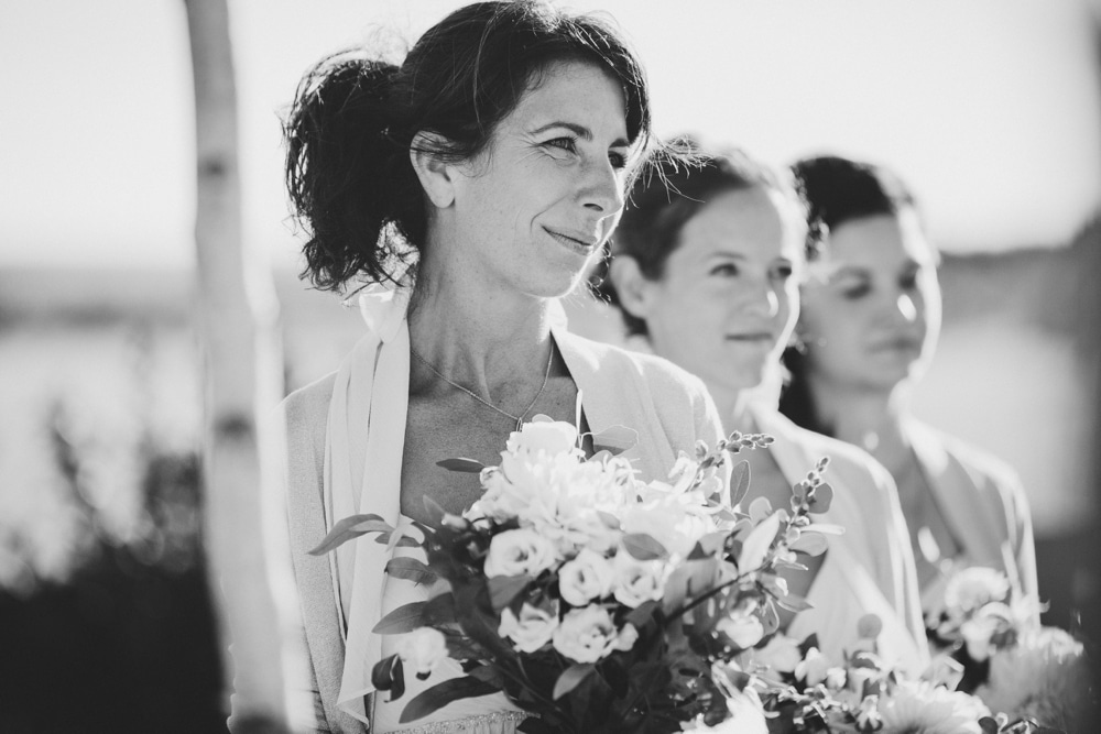 A documentary photograph of bridesmaids smiling during an outdoor Jewish wedding ceremony in Cape Cod, Massachusetts