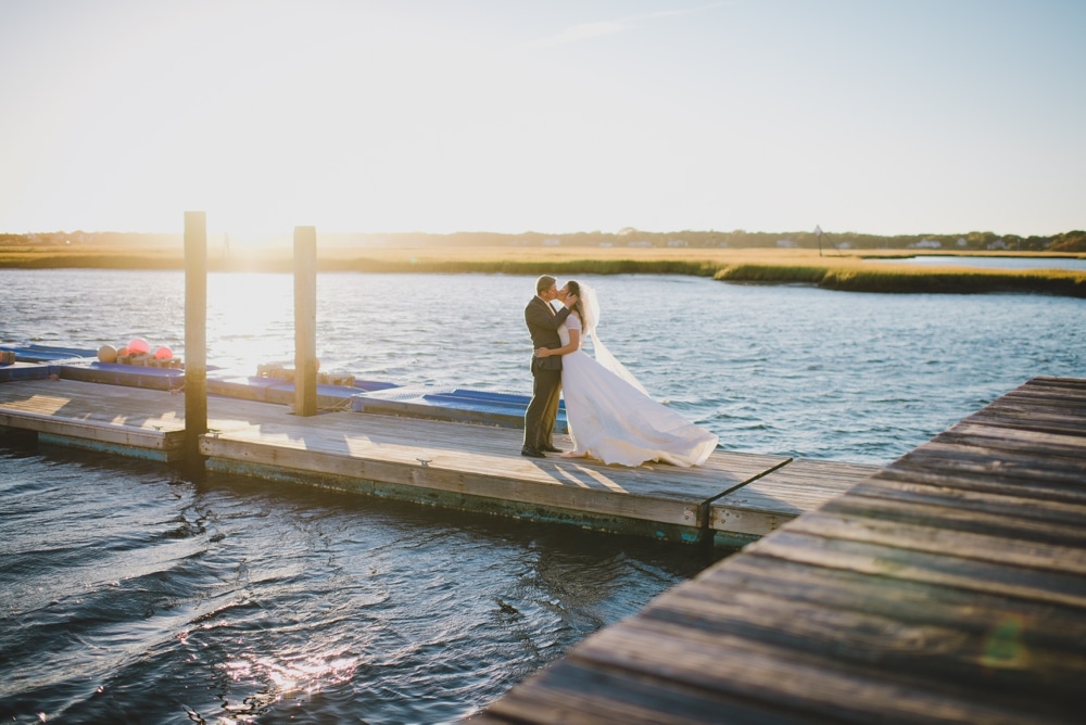 A documentary portait of a bride and groom kissing during their summer time wedding on Cape Cod
