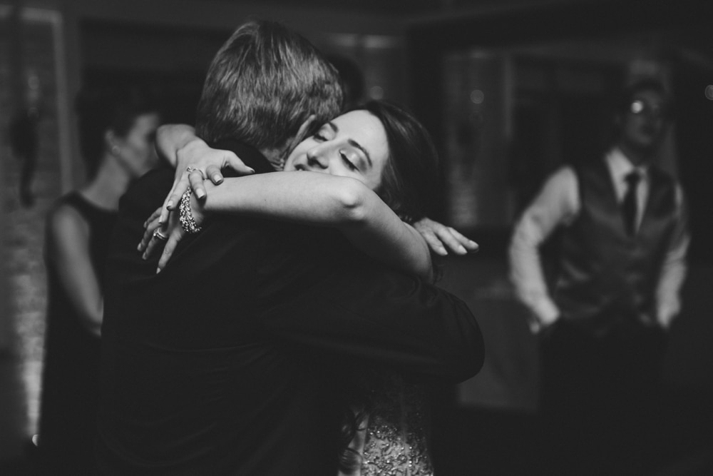 A documentary photograph of a bride hugging her father during the father daughter dance at an intimate Massachusetts wedding at the Oceanview of Nahant