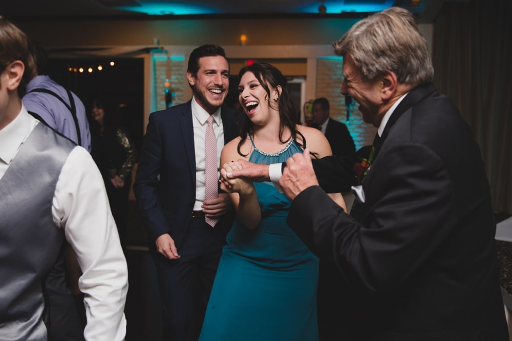 A documentary photograph of wedding guests dancing during an intimate Massachusetts wedding at the Oceanview of Nahant