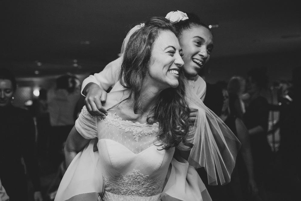 A photojournalistic photograph of a bride dancing with a junior bridesmaid during her summer time wedding in Cape Cod