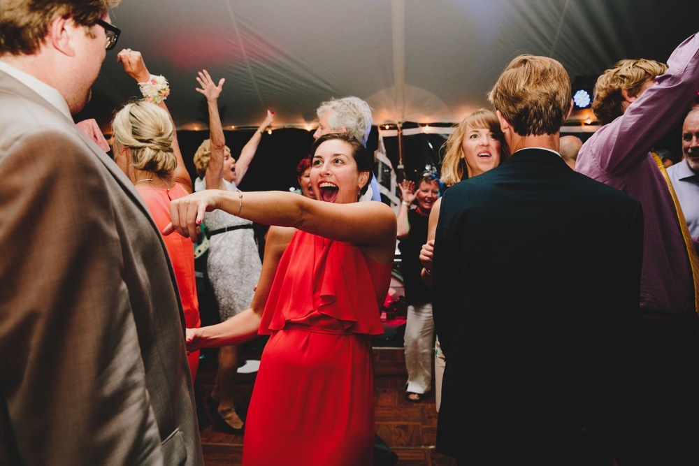 A fun photojournalistic photograph of wedding guest dancing during a fun, summertime, Cape Cod wedding at Pilgrim's Monument in Provincetown, Massachusetts