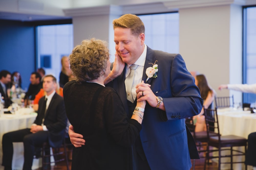 A documentary photograph of a groom dancing with his mother during a State Room Wedding in Boston