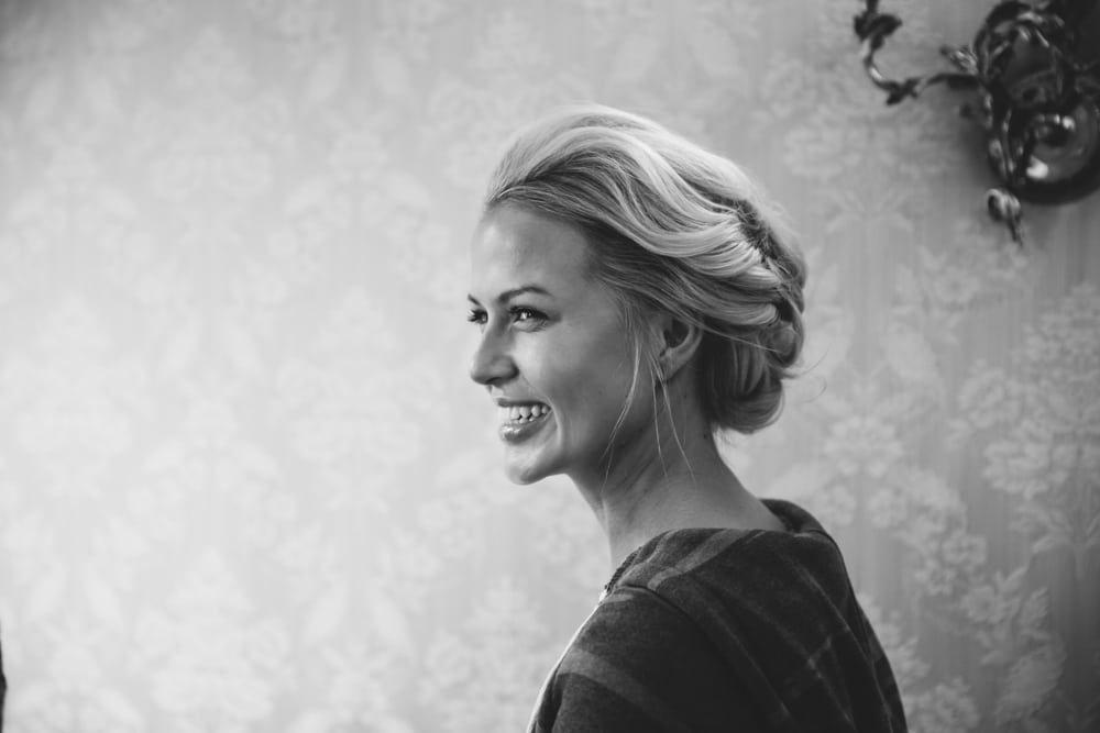 A documentary photograph of a bride smiling while she get ready for her Taj Boston Hotel Wedding in the Back Bay
