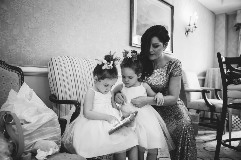 A documentary photograph of a two twin flower girls getting ready with their mom before a Taj Boston Hotel wedding