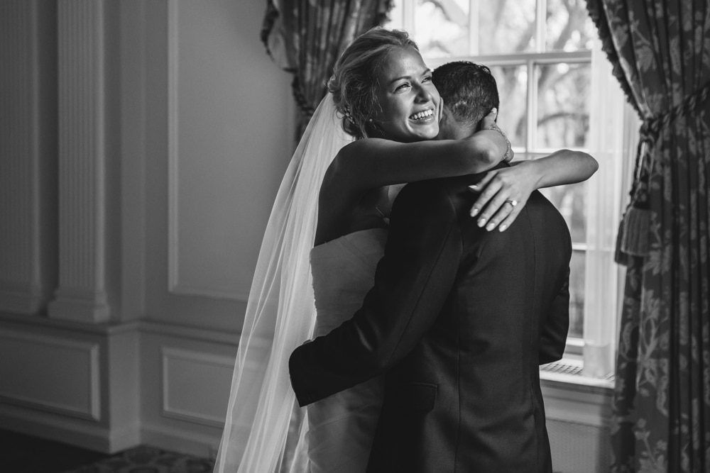 A documentary photograph of a bride and groom hugging during their first look of their Taj Boston Hotel Wedding in Massachusetts