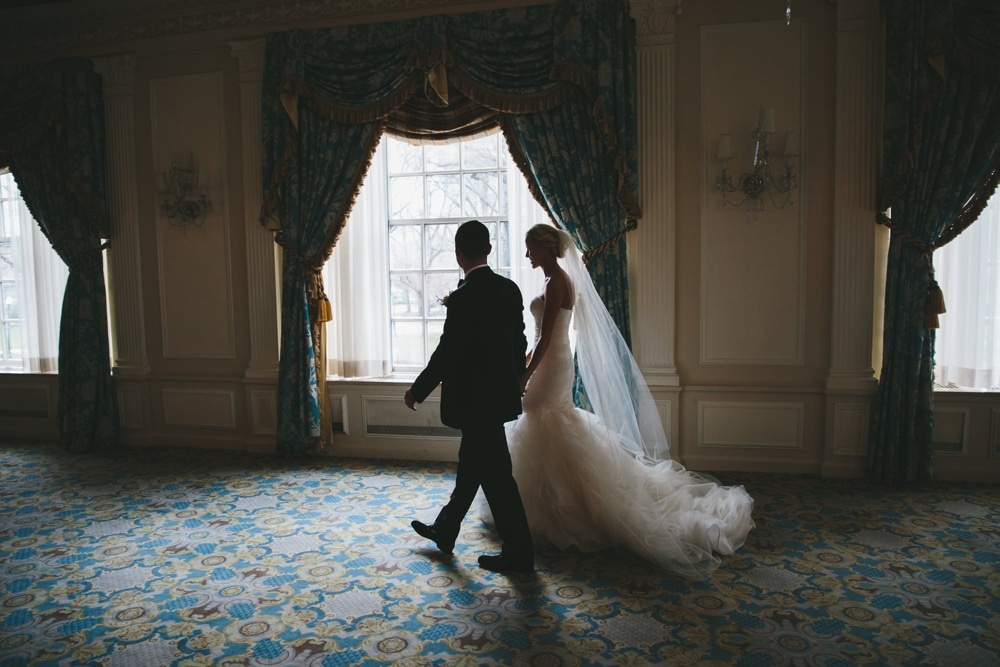 A documentary photograph of a bride and groom walking together during their first look at a Taj Boston Hotel Wedding