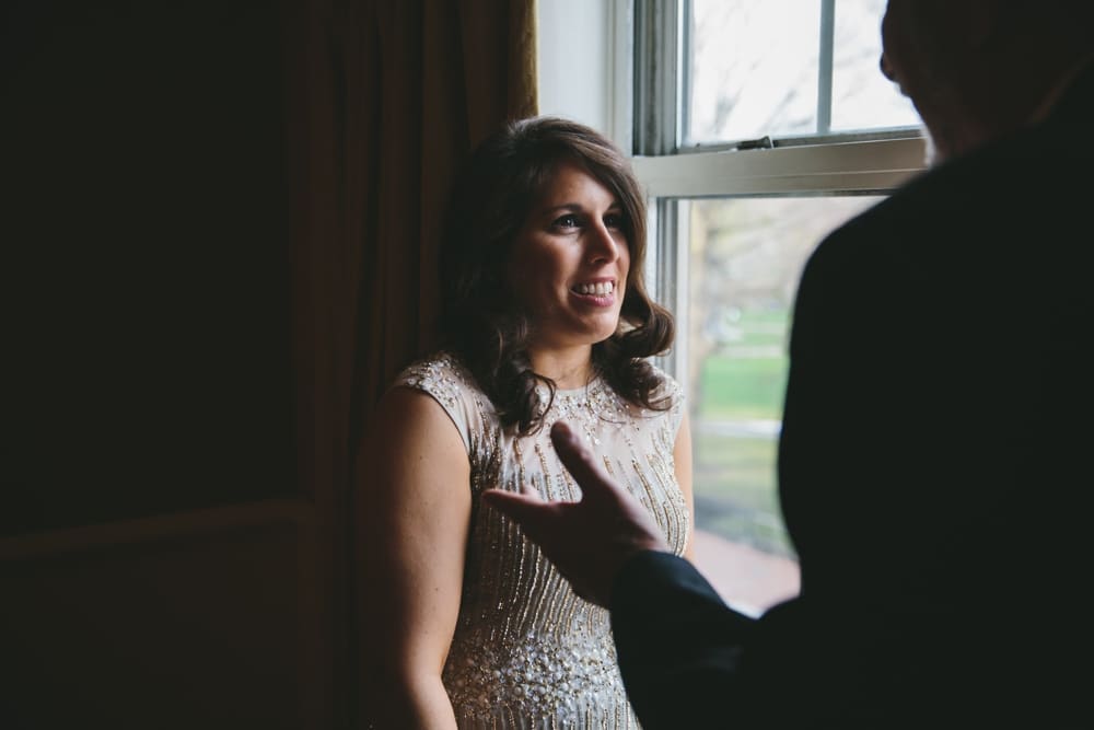 A documentary photograph of a bridesmaid talking with her uncle at a Taj Boston Hotel Wedding in Massachusetts