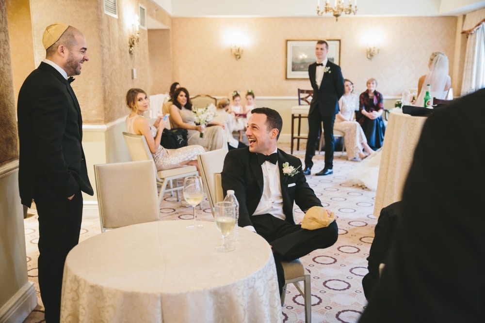 A documentary photograph of the wedding party talking and laughing during a Taj Boston Hotel Wedding in Massachusetts