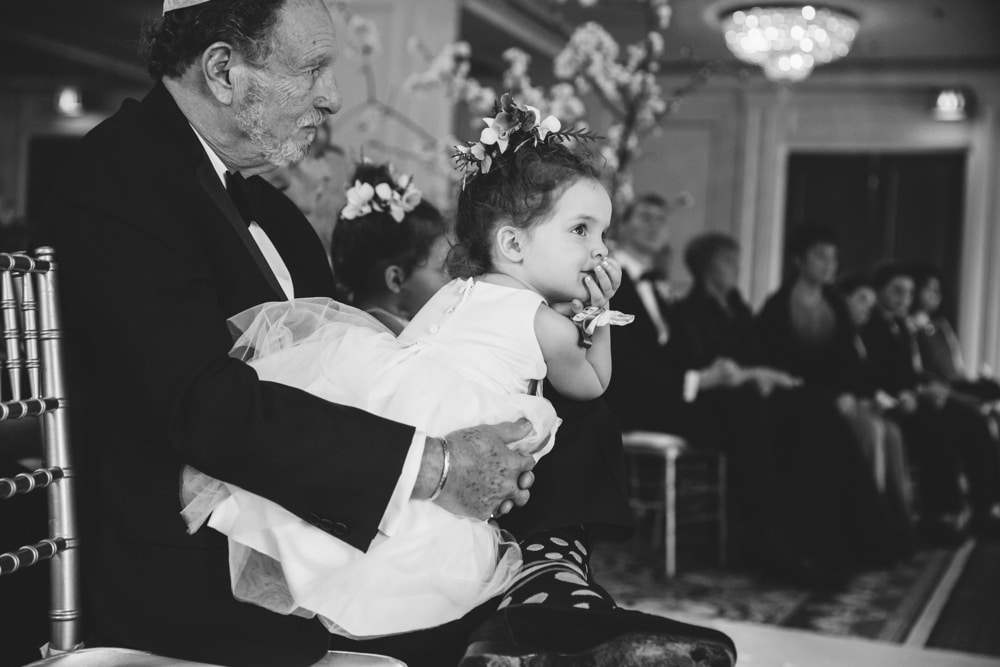 A documentary photograph of a flower girl watching the ceremony at a Taj Boston Hotel Wedding in Massachusetts