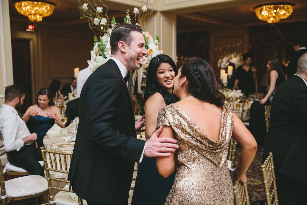 A documentary photograph of a guests talking and laughing during the reception of a Taj Boston Hotel Wedding in Massachusetts