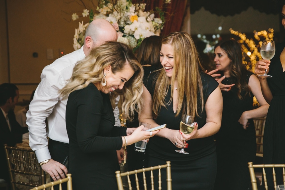 A documentary photograph of guest laughing during the reception of a Taj Boston Hotel wedding in Massachusetts