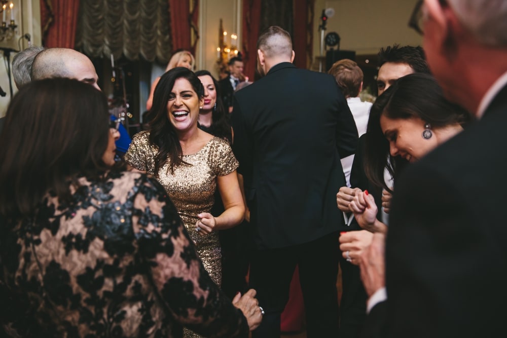 A documentary photograph of guests laughing on the dance floor during a Taj Boston Hotel Wedding in Massachusetts